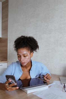 A Woman with Facial Cream on Face Browsing Her Smartphone