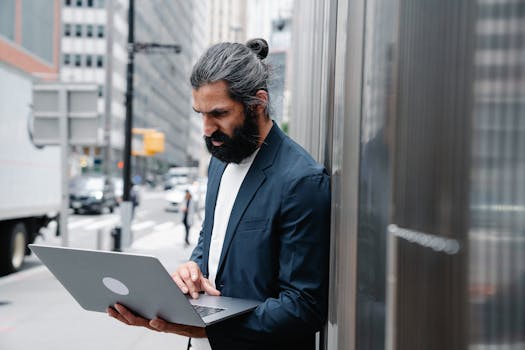 Focused Man using his Grey Laptop