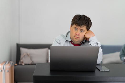 Man Sitting by Desk with Laptop