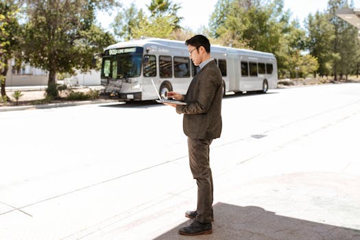 Man Using his Laptop While Standing on the Street