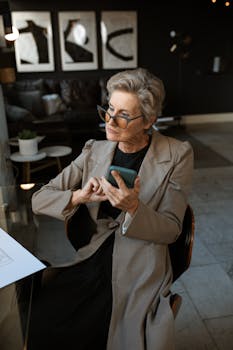 Man in Brown Suit Jacket Holding Blue Smartphone