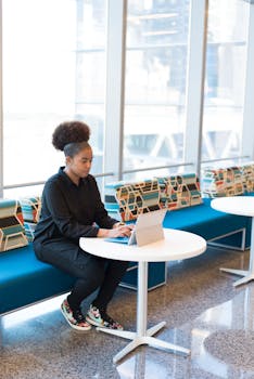 Woman in Black Outfit Working on a Laptop.